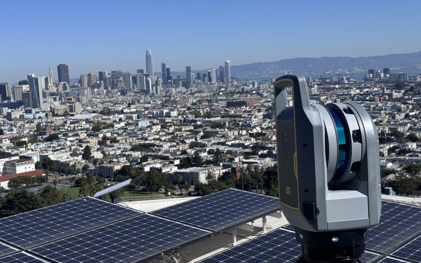 Contour Survey's Trimble X9 laser scanner on a San Francisco rooftop, with the downtown skyline and the Bay behind it